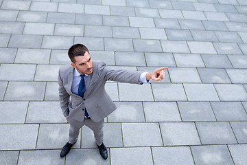 Image showing young smiling businessman outdoors from top