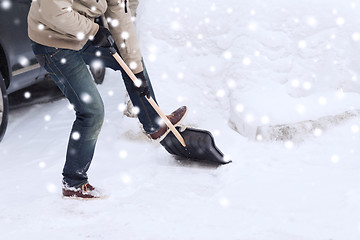 Image showing closeup of man digging snow with shovel near car