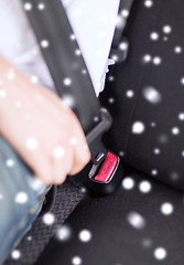 Image showing close up of man fastening seat belt in car