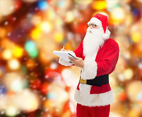 Image showing man in costume of santa claus with notepad