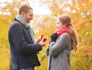 Image showing smiling couple with engagement ring in gift box