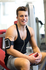Image showing smiling sportsman with smartphone and earphones