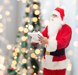 Image showing man in costume of santa claus with notepad