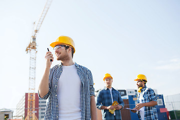 Image showing group of smiling builders in hardhats with radio