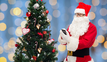 Image showing santa claus with smartphone and christmas tree