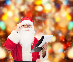 Image showing man in costume of santa claus with notepad