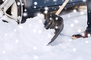 Image showing closeup of man digging snow with shovel near car