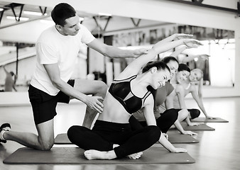 Image showing group of smiling women stretching in the gym