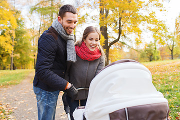 Image showing smiling couple with baby pram in autumn park