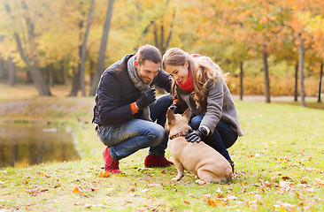 Image showing smiling couple with dog in autumn park