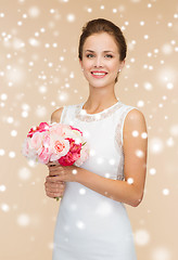 Image showing smiling woman in white dress with bunch of flowers