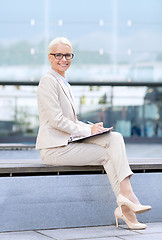 Image showing young smiling businesswoman with notepad outdoors