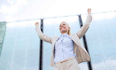 Image showing young smiling businesswoman over office building