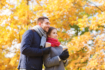 Image showing smiling couple with coffee cups in autumn park