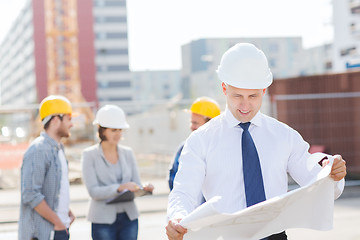 Image showing group of builders with tablet pc and blueprint