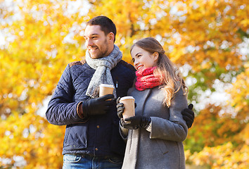 Image showing smiling couple with coffee cups in autumn park