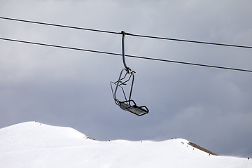 Image showing Chair lift and off-piste slope at gray day