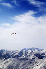 Image showing Parachutist silhouette of mountains in windy sky