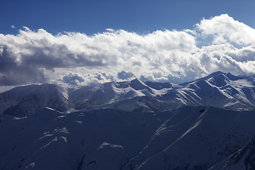 Image showing Evening sunlight mountain with clouds and silhouette of paraglid