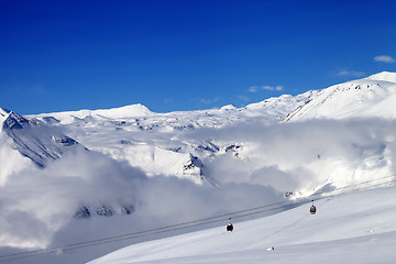 Image showing Off-piste snowy slope and cable car at sun day