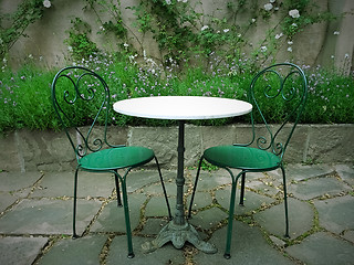 Image showing Chairs and table in a magic summer garden 