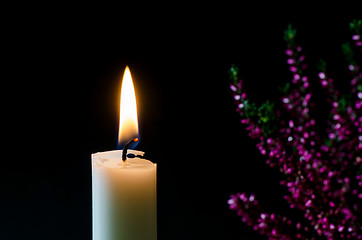 Image showing Burning candle in front of heather flower