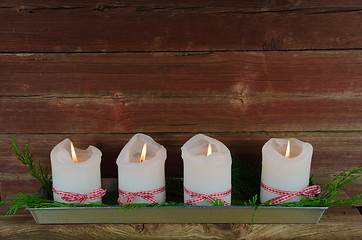 Image showing Four advent candles at an old weathered red wall 