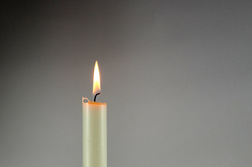 Image showing One white candle at grey background