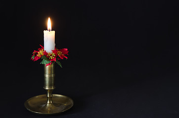 Image showing Christmas decorated candle at a black background