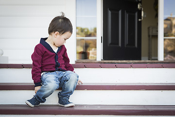Image showing Melancholy Mixed Race Boy Sitting on Front Porch Steps