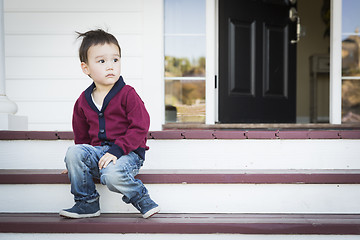 Image showing Melancholy Mixed Race Boy Sitting on Front Porch Steps