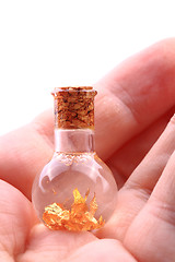 Image showing gold in small glass bottle 