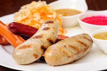 Image showing German sausage with cabbage and sauces