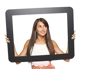 Image showing Woman looking to side through tablet frame