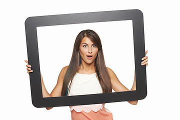 Image showing Excited woman looking through tablet frame