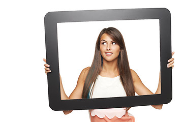 Image showing Woman looking to side through tablet frame