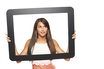 Image showing Woman looking to side through tablet frame