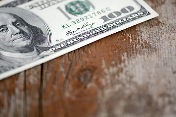 Image showing Close-up of a $100 banknotes on wooden background