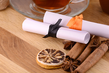 Image showing hot tea with lemon and cinnamon on wooden backgroubd