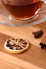 Image showing hot tea with lemon and cinnamon on wooden backgroubd