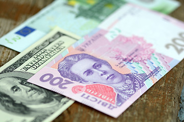 Image showing dollars euro and hryvnia banknotes on wooden background