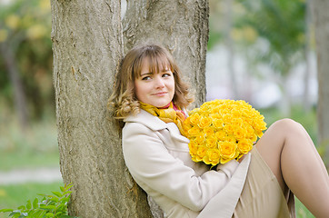 Image showing Cute little girl with yellow roses saw a familiar