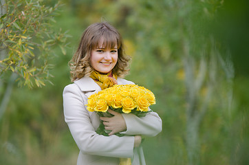 Image showing Beautiful girl with a bouquet of yellow roses