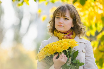 Image showing Sad girl with a bouquet of yellow roses