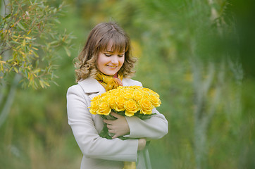 Image showing Happy girl with a bouquet of yellow roses