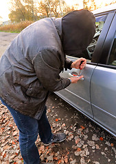 Image showing Hooligan breaking into car