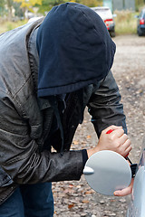 Image showing Hooligan breaking into car