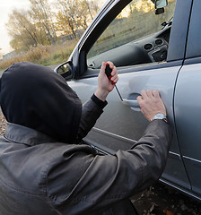 Image showing Hooligan breaking into car