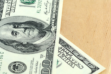 Image showing Close-up of a 100 dollars banknotes on wooden background