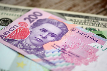 Image showing dollars euro and hryvnia banknotes on wooden background